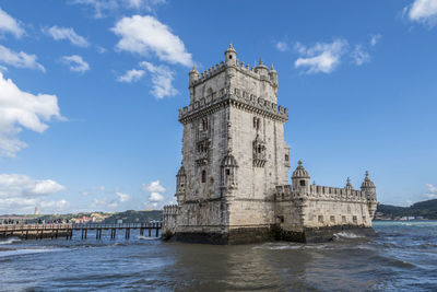 View of historic building by sea against sky