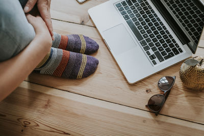 Low section of woman in front of a laptop at home