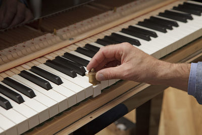 Midsection of examining man playing piano