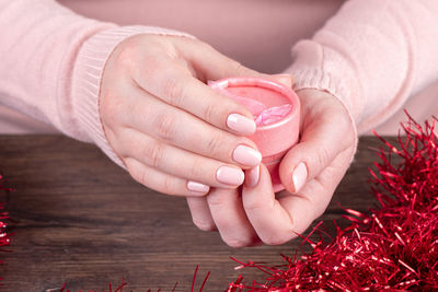 Cropped hand of woman holding heart shape on table