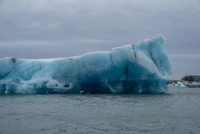 Ice floating on sea against sky during winter