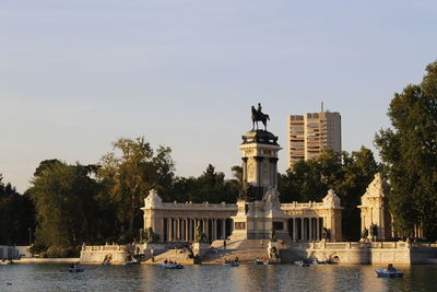 Monument to alfonso xii of spain in el retiro park, madrid, rowing boats on the lake