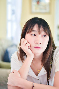 Portrait of young woman sitting at home