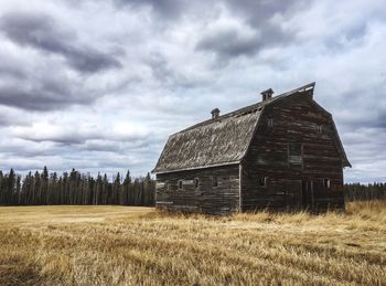 Abandoned building on field against sky