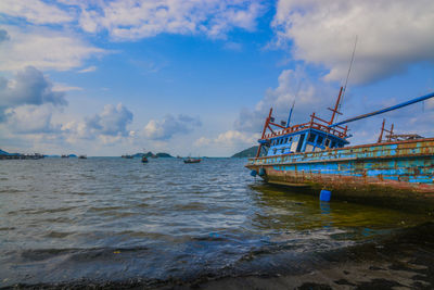 Fishing boats in sea against sky