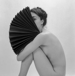 Side view of woman standing against white background