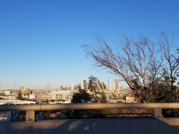 Cityscape by river against clear sky