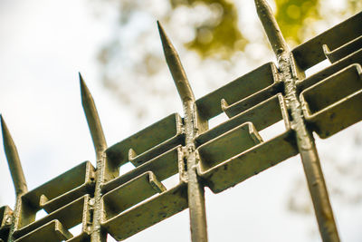 Low angle view of fence against sky