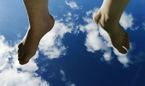 Low section of man against blue sky