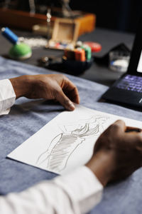 Cropped hand of businessman working on table