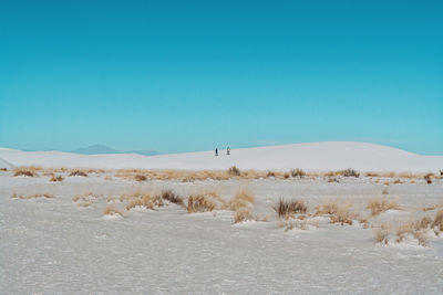 Scenic view of desert against clear blue sky