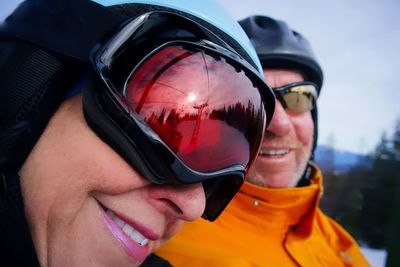 Close-up of smiling couple wearing ski goggles