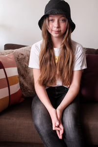 Portrait of young woman sitting on sofa at home