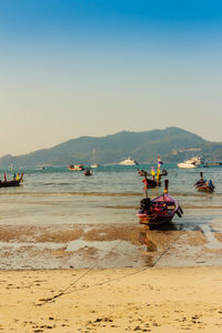 Boats at beach against sky