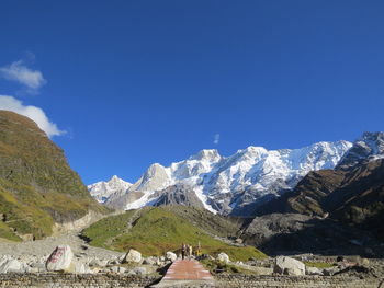 Panoramic view of snowcapped mountains against clear blue sky