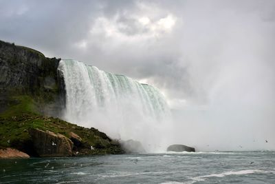 Scenic view of waterfall against sea