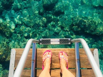 Low section of woman relaxing in swimming pool