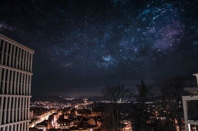 Low angle view of illuminated city against sky at night