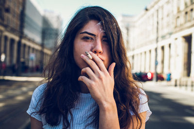 Portrait of young woman on street in city