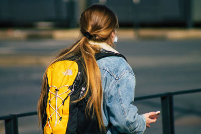 Rear view of woman standing by railing