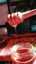 Close-up of hand pouring drink in glass