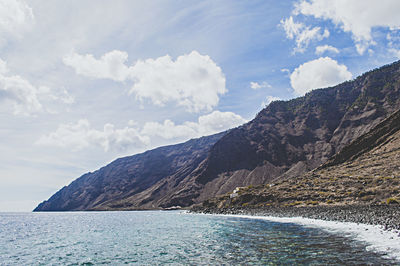 Scenic view of sea and mountains against sky