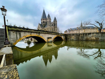 Arch bridge over river against sky