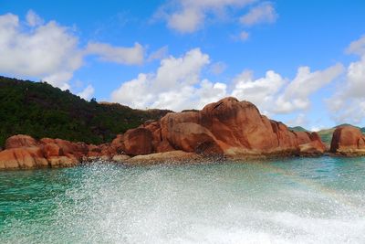 Rock formations by sea against sky