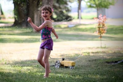 Girl smiling while standing on grass