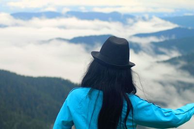 Rear view of woman wearing hat against mountains