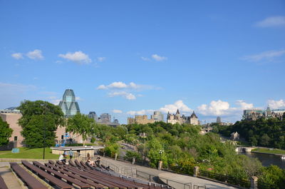 Trees and buildings against blue sky