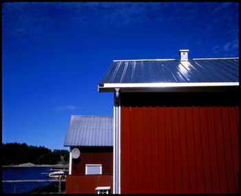 Low angle view of cottage against blue sky