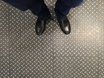 Low section of man standing on tiled floor