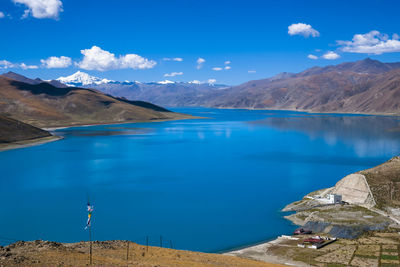 Scenic view of lake and mountains against blue sky