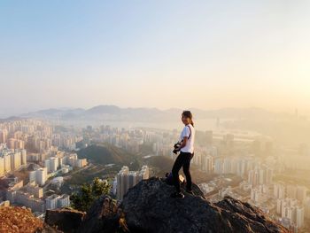 Full length of man standing on city buildings against sky