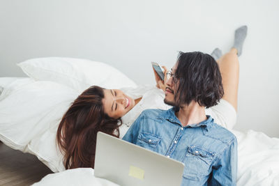 Young woman using laptop on bed at home