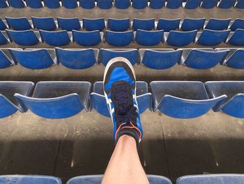 Low section of man wearing shoe against stadium seats