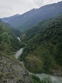 Scenic view of river amidst mountains against sky