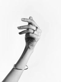 Close-up of woman hand holding paper over white background