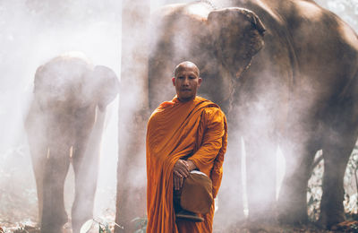 Full length of man standing against waterfall