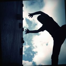 Low angle view of people against cloudy sky