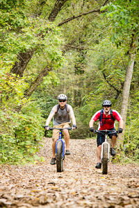 Men mountain biking in forest