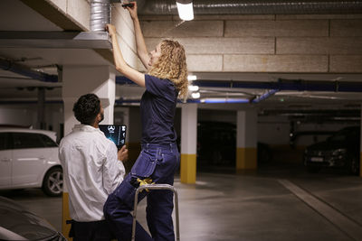 Man and woman checking air duct
