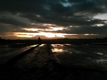 Scenic view of dramatic sky over land during sunset