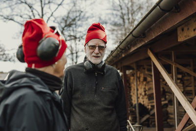 Senior man in front of wood shed