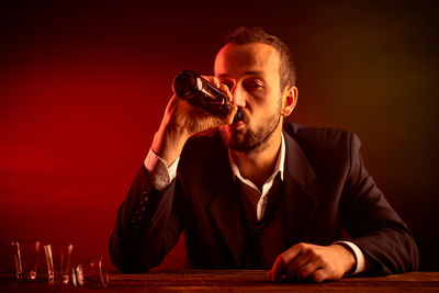 Portrait of a man with drink sitting on table