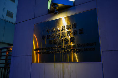 Low angle view of illuminated text on building at night