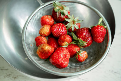 Bright sweet and juicy strawberries . red strawberries in an iron colander. drops of water a berries