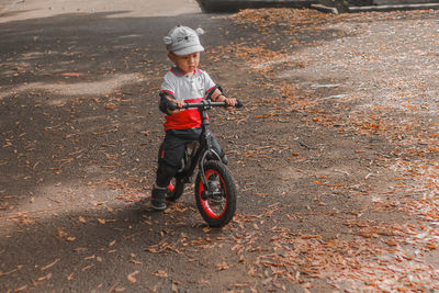 Portrait of cute toddler boy riding a push bike