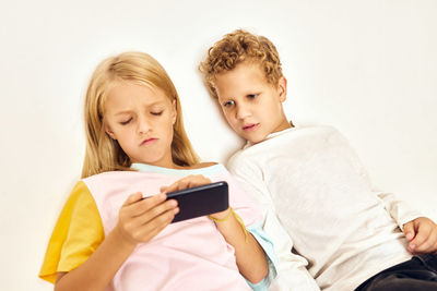 Happy woman using mobile phone while sitting on laptop